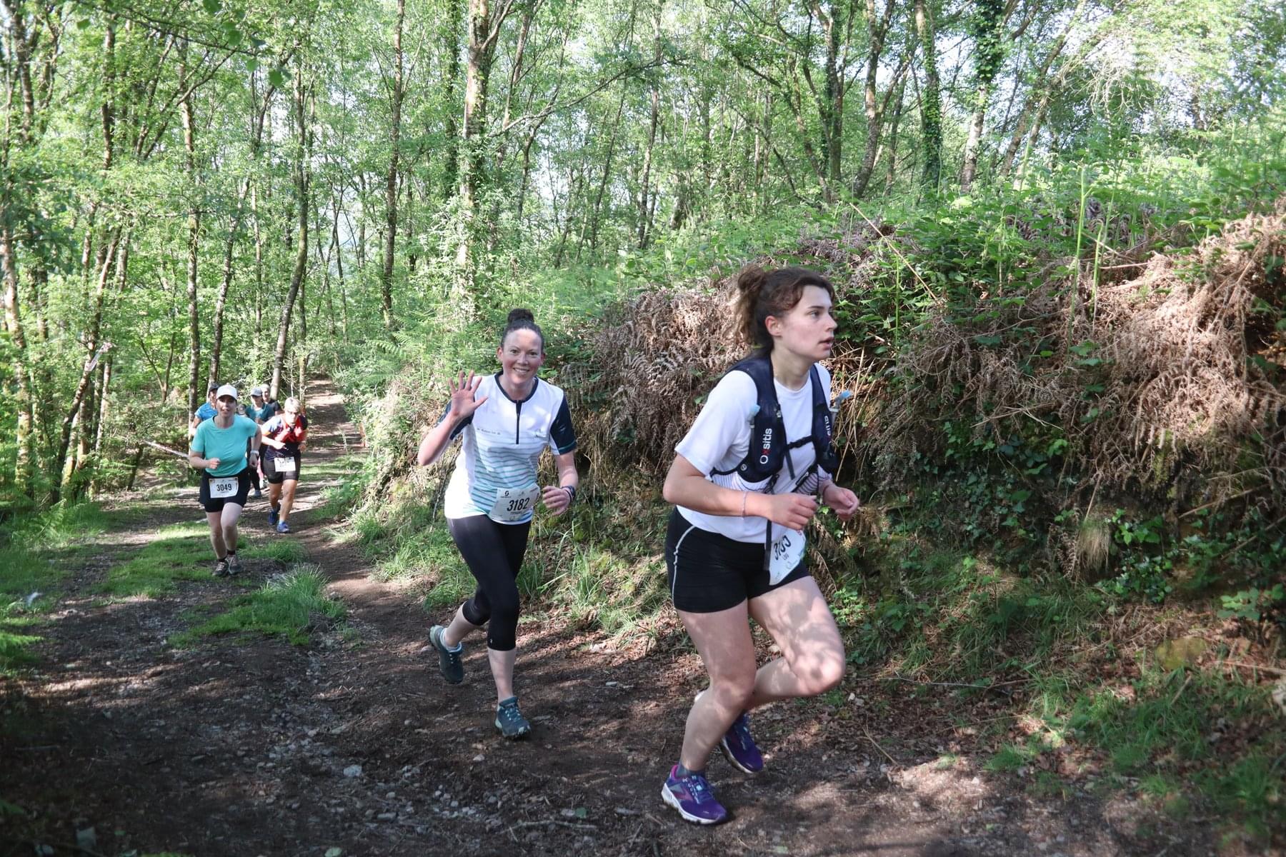 Des coureuses et coureurs sur les sentiers boisés du Trail de Guerlédan